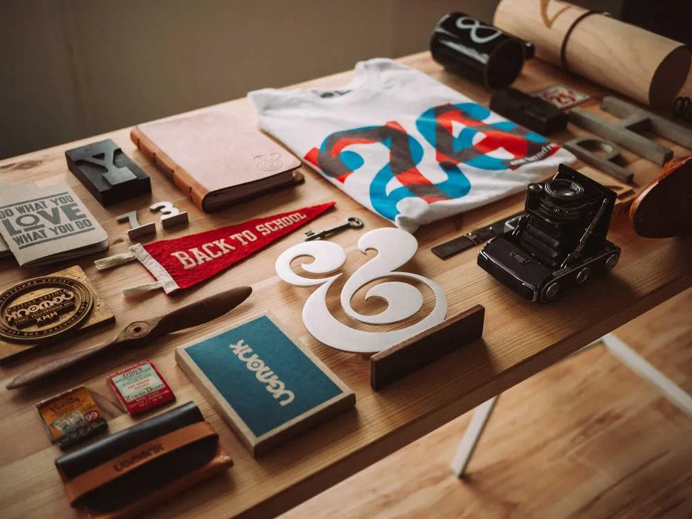 A flat lay of a desk with a notebook, pens and a laptop