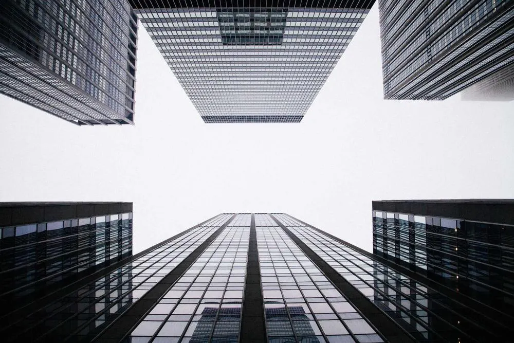 Looking up at modern skyscrapers converging against the sky