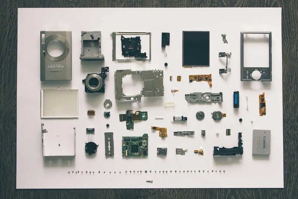 Camera parts laid out precisely on a white surface
