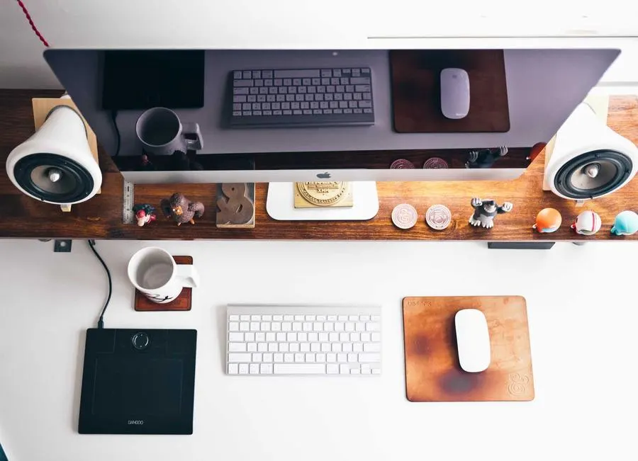 A tidy desk setup with a monitor, speakers and a keyboard