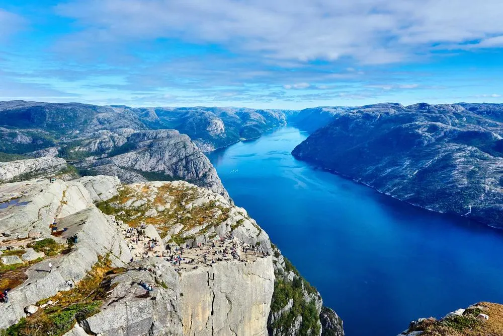 A fjord under heavy cloud, the water flat and silver after a storm