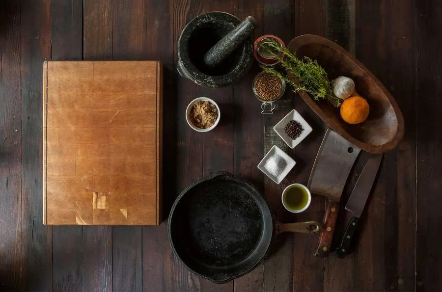 Spices, a pan and a wooden board laid out for cooking