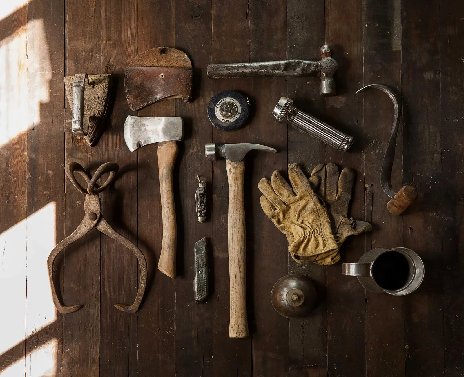 Carpentry hand tools laid out neatly on a dark workbench
