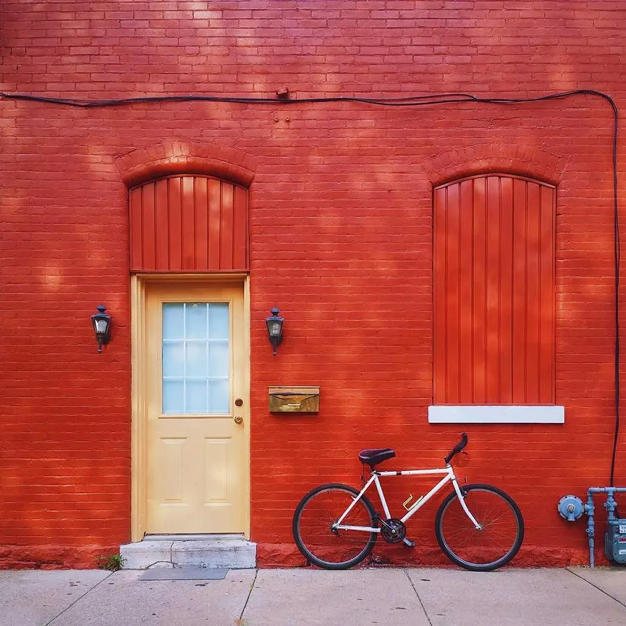 A freshly painted red door with a bicycle leaning beside it